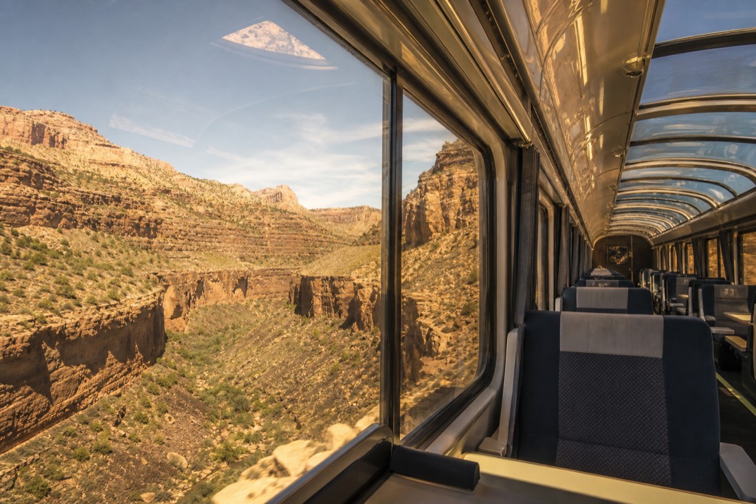 Interior of an upgraded railway car with wide windows and comfortable seating set up for the canyon run