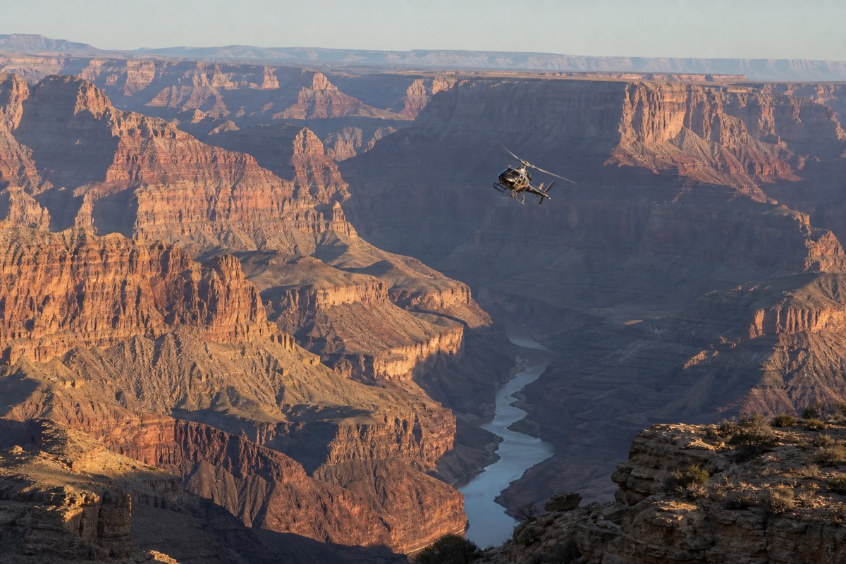 A sightseeing helicopter banking over the Grand Canyon with the river far below