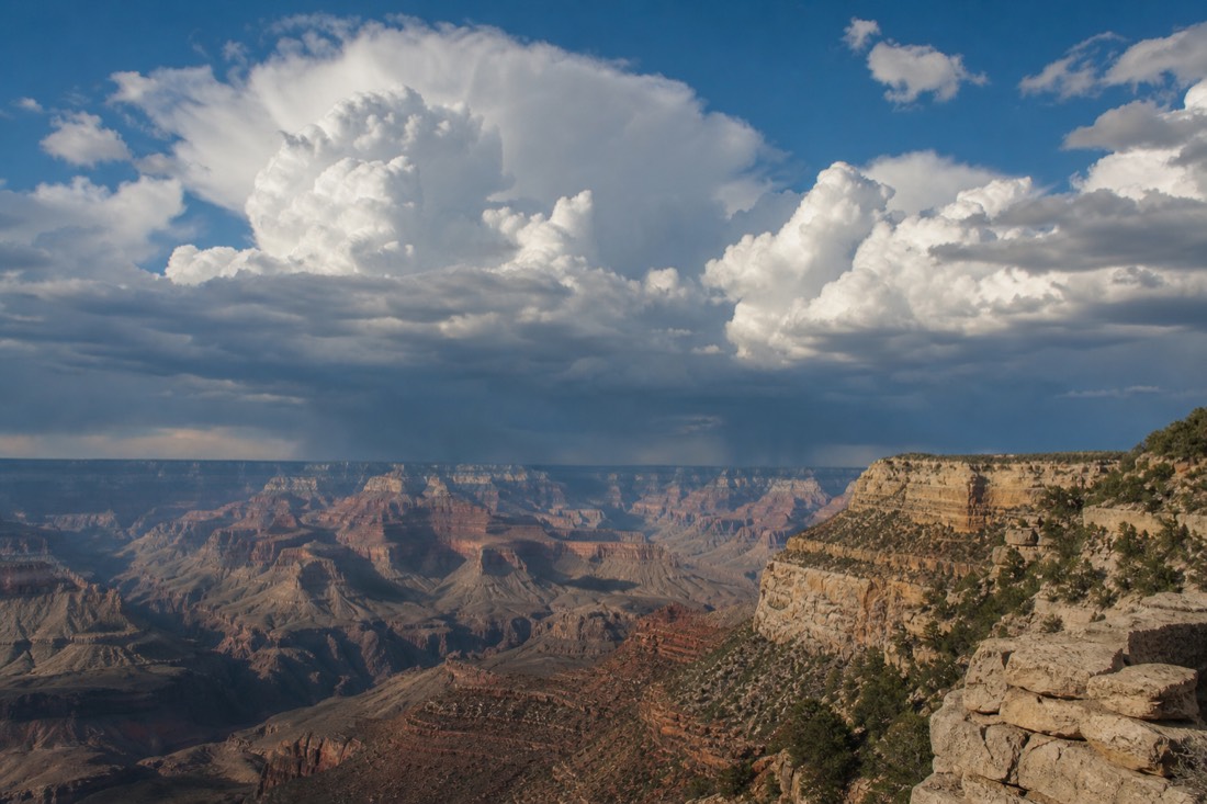 Towering cumulus clouds stacking over the Grand Canyon in late morning before an afternoon monsoon storm breaks