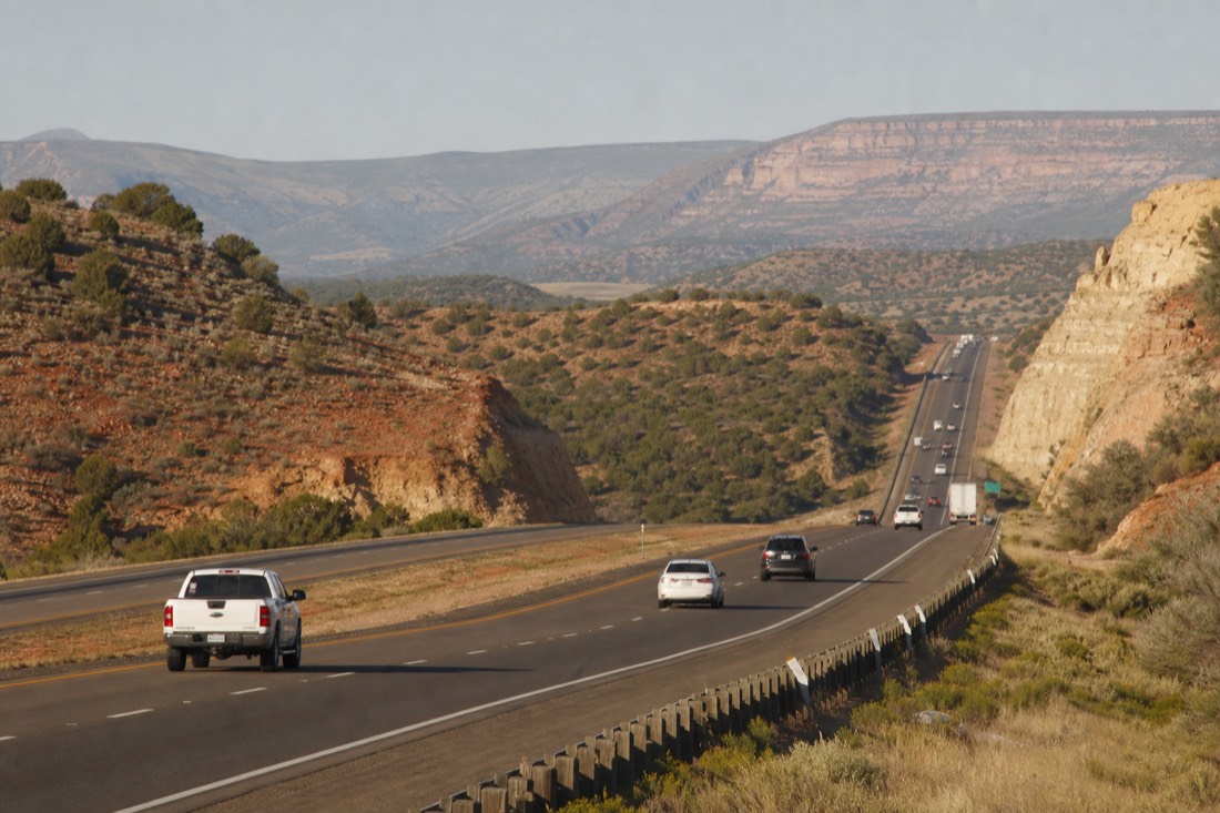 Northbound Interstate 17 traffic climbing a long grade toward the Mogollon Rim with juniper hills on both sides