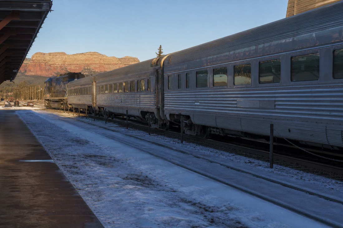 A vintage train waiting at a snowy Williams depot platform in the blue light before departure