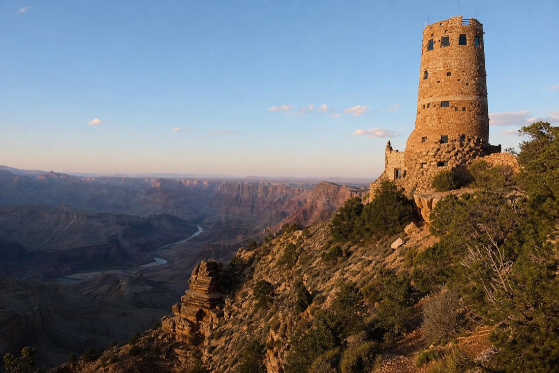 The stone Desert View Watchtower standing at the canyon edge with the Colorado River bending far below